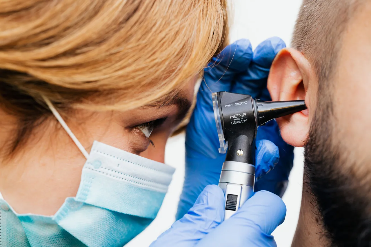 Close-up of a doctor performing an ear examination with an otoscope