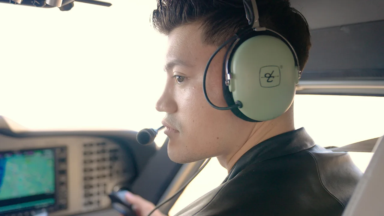 Young pilot wearing headset inside cockpit